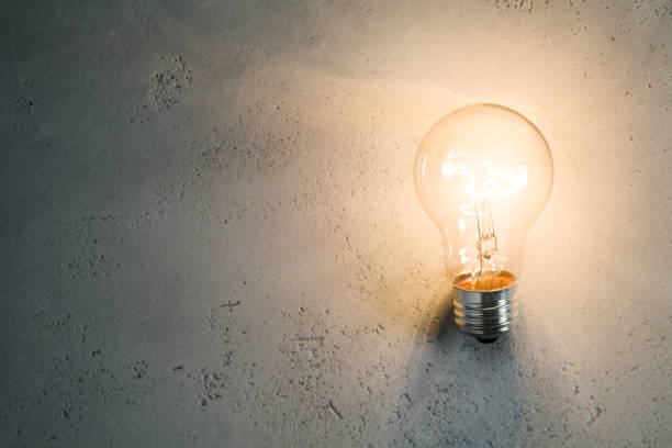 istock Vintage incandescent bulb on concrete background 853916458