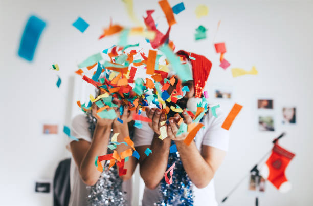 istock Couple blowing confetti out of their hands 853919578