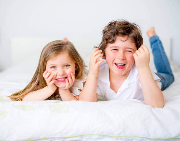 istock Brother And Sister Relaxing Together In Bed 853920284