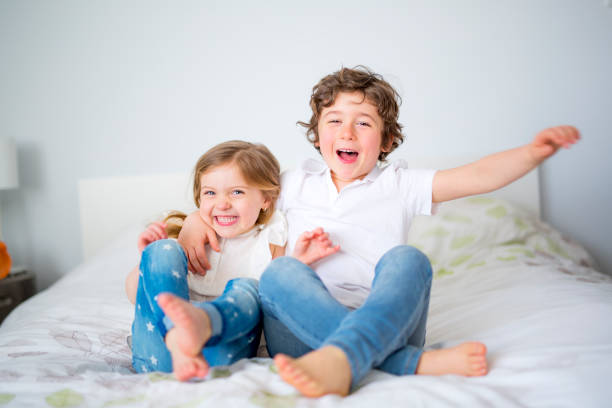 istock Brother And Sister Relaxing Together In Bed 853920626