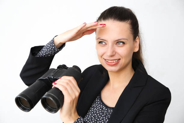 istock Girl on a white background looks through binoculars 853923328