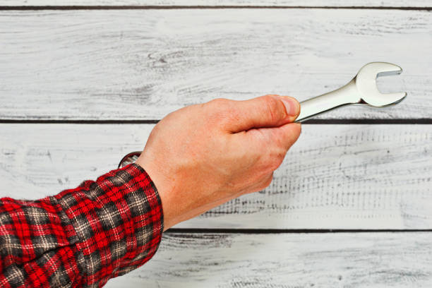 Studio shot of maintenance man holding wrench