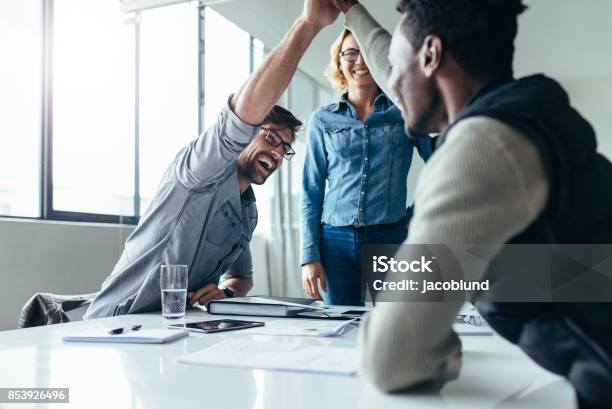 Two Colleagues Giving High Five During Meeting Stock Photo - Download Image Now - High-Five, Business, Celebration