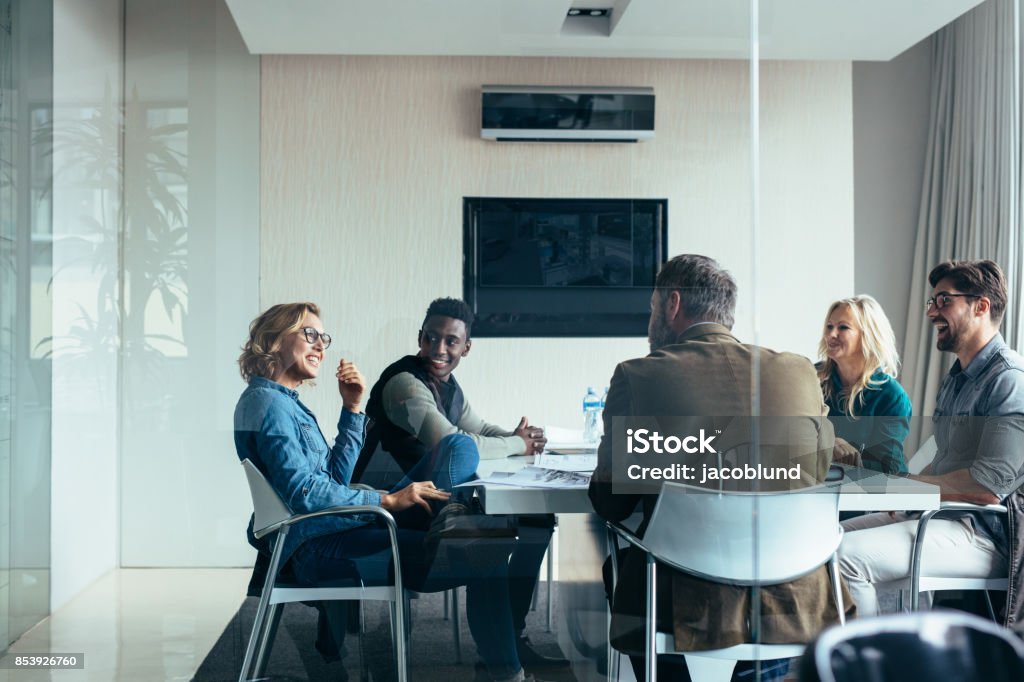 Female manager leads brainstorming meeting in office Female manager leads brainstorming meeting in design office. Businesswoman in meeting with colleagues in conference room. Meeting Stock Photo