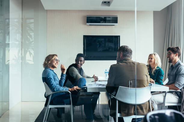 female manager leads brainstorming meeting in office - grupo pequeno de pessoas imagens e fotografias de stock