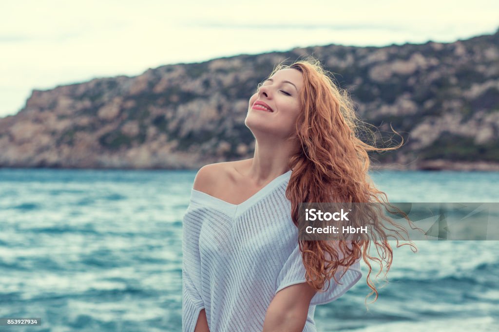 woman on the beach taking deep breath enjoying fresh air freedom Hair Stock Photo