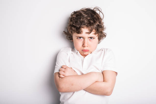 Head and Shoulders Close Up Portrait of Young boy with Sulk attitude A Head and Shoulders Close Up Portrait of Young boy with Sulk attitude sulking stock pictures, royalty-free photos & images