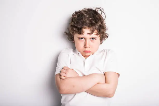 Photo of Head and Shoulders Close Up Portrait of Young boy with Sulk attitude