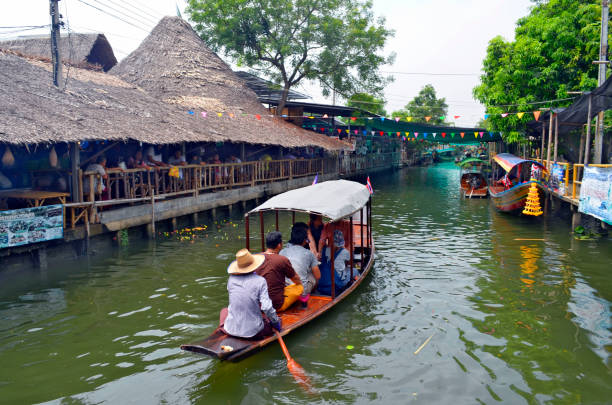 Damnoen Saduak, Thailand - Thai lady selling food, drink and ice cream from a boat at Damnoen Saduak floating market
