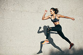 istock Fit young woman jumping and running 853930556