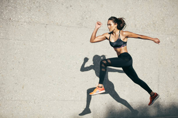 fit młoda kobieta skacze i biega - exercising stretching women outdoors zdjęcia i obrazy z banku zdjęć