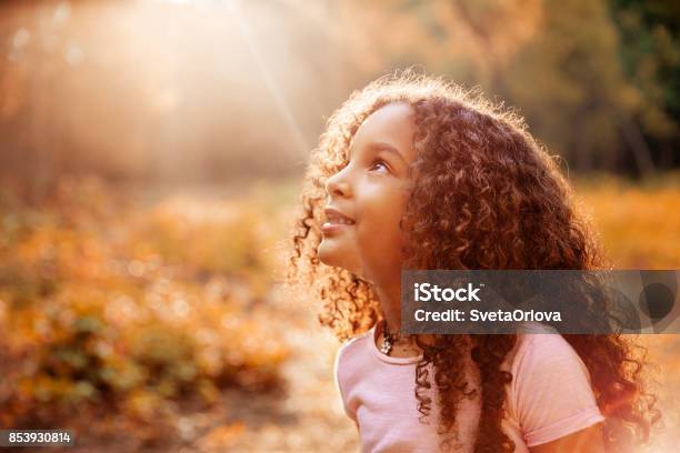 Afro Americano Carino Bambina Con I Capelli Ricci Riceve Raggi Solari Miracolosi Dal Cielo - Fotografie stock e altre immagini di Bambino