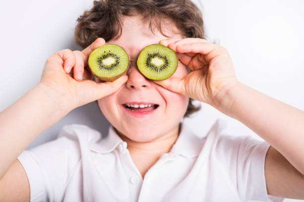 istock Beautiful boy child holding kiwi 853931170