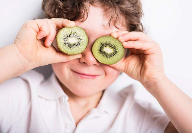 istock Beautiful boy child holding kiwi 853931214
