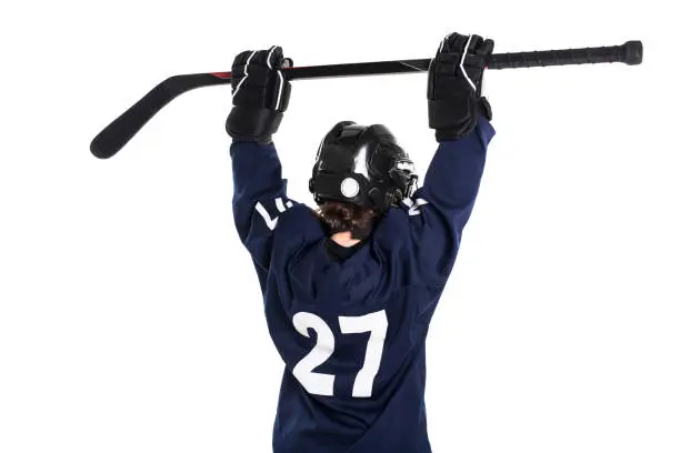 Photo of Young boy in ice hockey gear against white