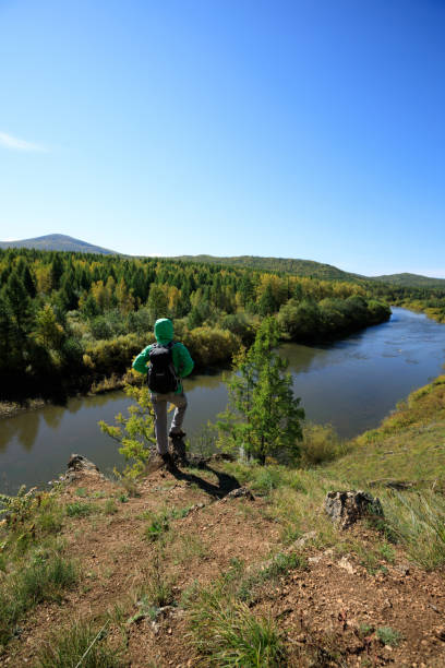 istock woman hiking with backpack at the riverside mountain 853940262