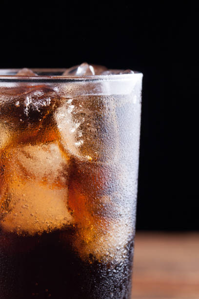 istock Close up on a cold refreshing soft drink with ice on a dark wooden background 853940358