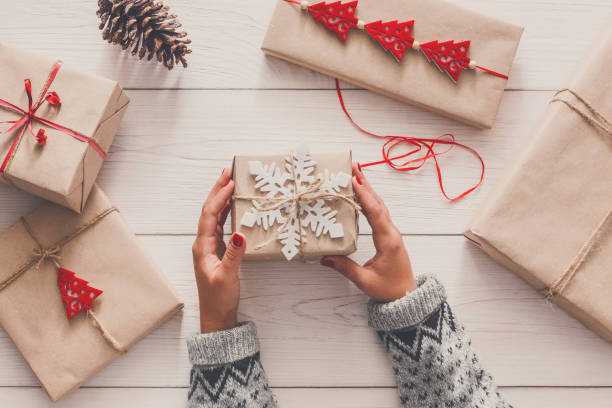 istock Woman's hands wrapping christmas holiday present with craft twine 853947048