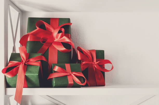 istock Holiday presents, gift boxes on white shelves at wall background 853947686