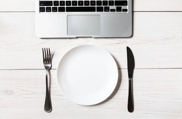 istock Business or diet concept, workplace with laptop and empty plate with cutlery 853955058