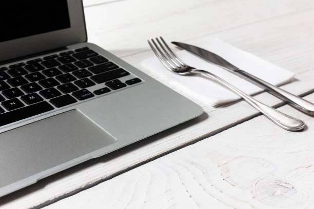 istock Business or diet concept, workplace with laptop and cutlery 853955632