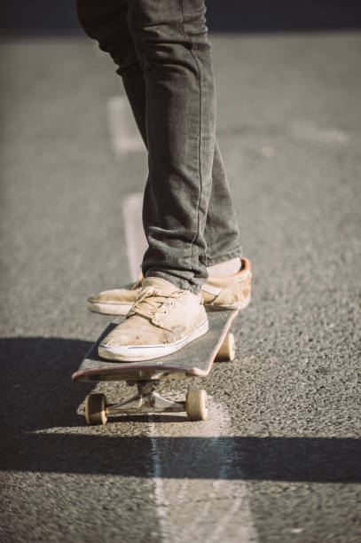 istock Skateboarder legs riding skateboard on the street 853960396