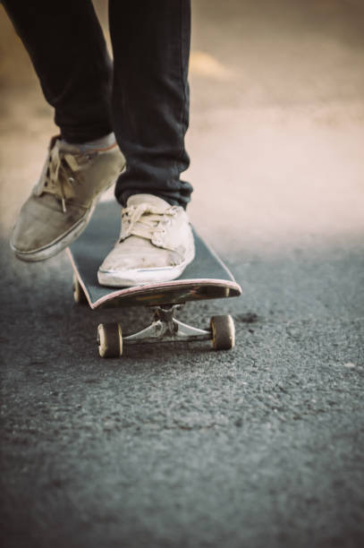 istock Skateboarder legs riding skateboard on the street 853960606