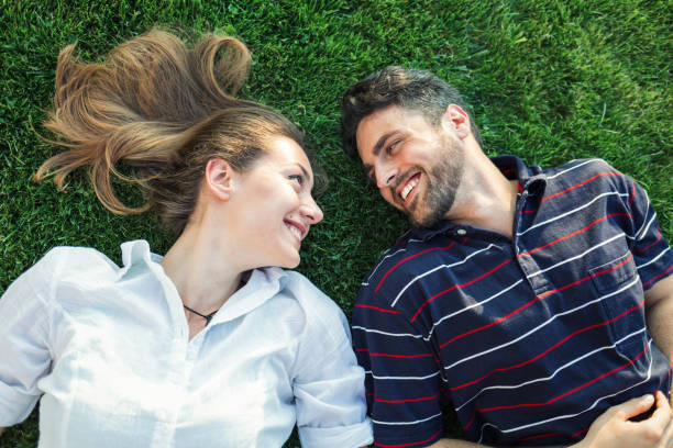 istock Beautiful couple lying on the grass and feeling happy together 853964014