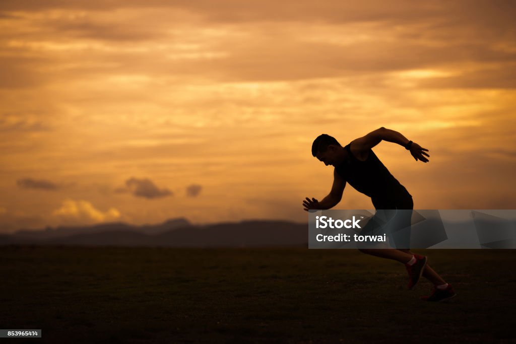 Asian men are siluate jogging at a speed in the evening Running Stock Photo