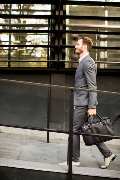istock Businessman in suit with leather handbag goes to work 853965860