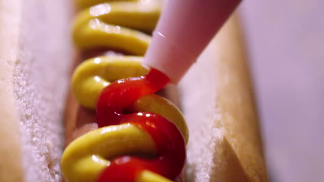 Preparing Hot Dog with Mustard and Ketchup