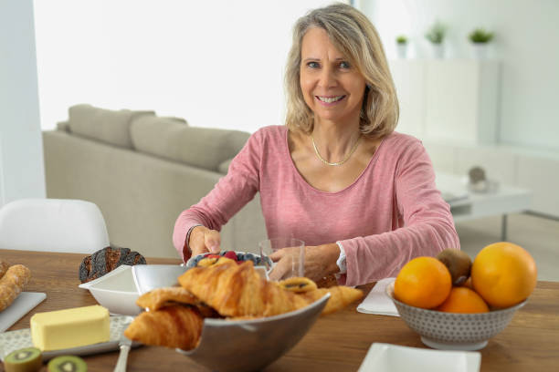 istock senior woman having french breakfast 853973774
