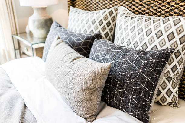 nahaufnahme der neuen bett tröster mit dekorativen kissen, kopfteil in schlafzimmer in home staging modell, haus oder wohnung - cushion pillow textile luxury stock-fotos und bilder