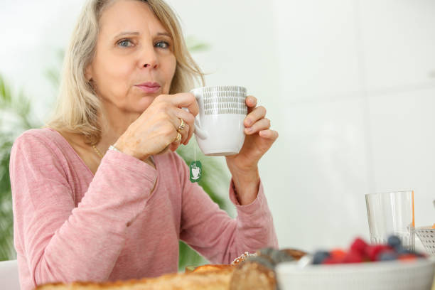 istock senior woman having french breakfast 853974166