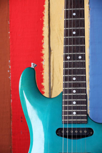istock electric guitar with grunge colorful wooden panel as background. 853976336