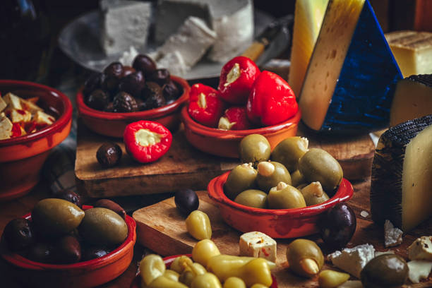 Variation of Spanish Appetizer Good Quality Cheese, Olives and Filled Bell Peppers on Rustic Background