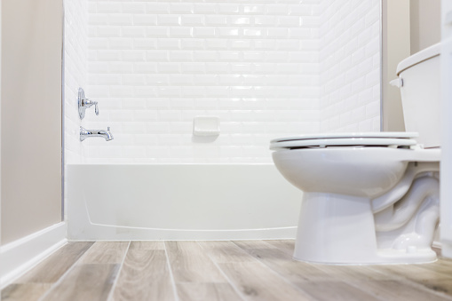 Moderno blanco llano limpio aseo con ducha azulejos y pisos de madera desde el suelo photo