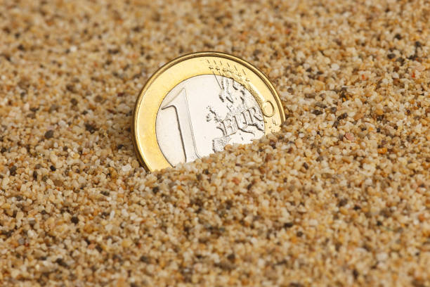 istock 1 euro coin in the sand 853977656