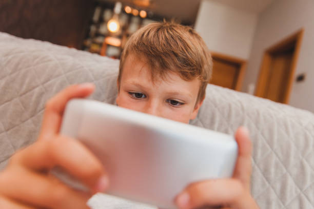 istock Young Boy Playing Games on Smart Phone 853978128