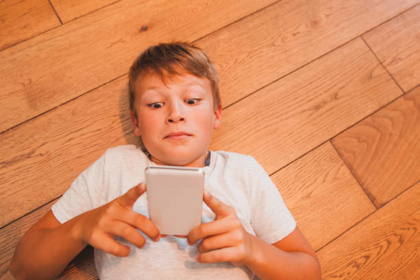 istock Young Boy Playing Games on Smart Phone 853978174