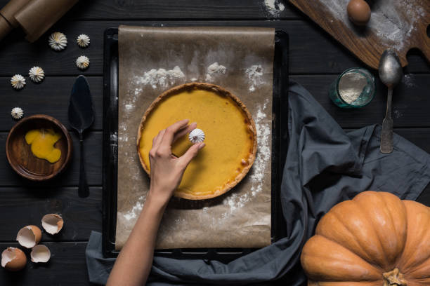 istock female hand placing meringue onto pie 853982144