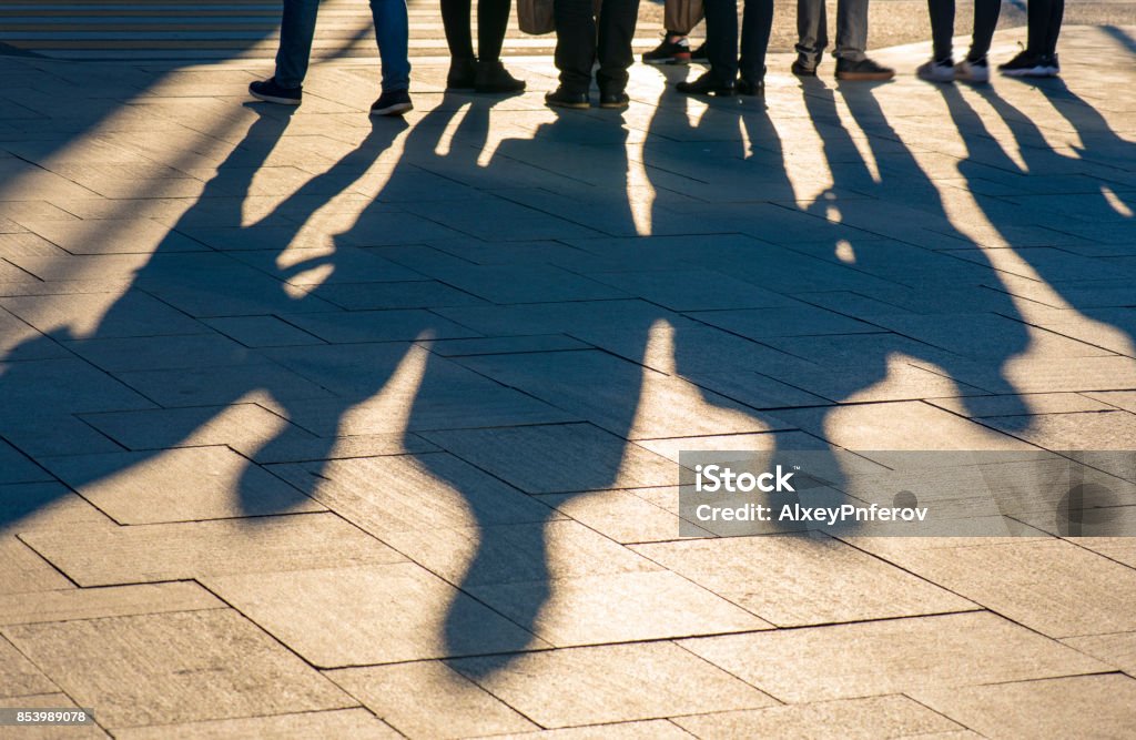 Sombras y siluetas de personas en una ciudad durante el atardecer - Foto de stock de Sombra libre de derechos