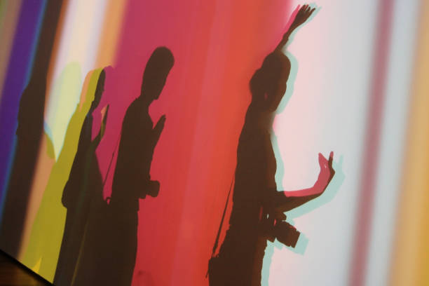 Silhouette shadow of three happy people make Buddhist hand sign posting on white wall with colorful light spots