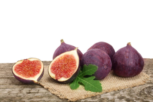 istock fig fruits with leaves on old wooden table with white background 853990936