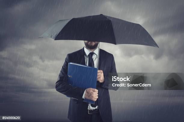 Businessmen With Umbrella Standing In Stormy Raininsurance Agent And Consultant In Business Crisis Situation Stock Photo - Download Image Now