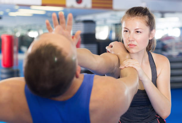 istock Woman and trainer practicing punches in gym 854001068