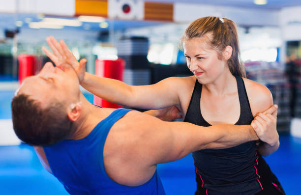 istock Woman is training with man on the self-defense course in gym. 854001134