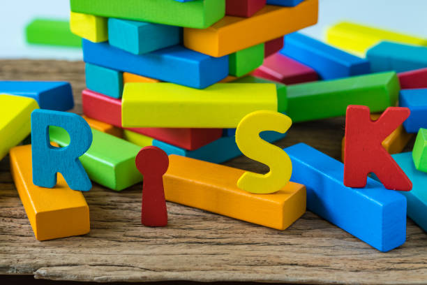 istock risk concept with colorful wooden alphabets RISK on collapse wooden blocks tower 854011570