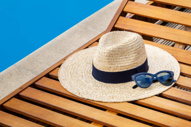 istock Straw hat with sunglasses near swimming pool 854011596
