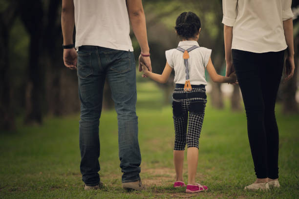 Daughters, parents were holding hands in the park stock photo